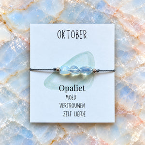 Maandarmband oktober op bijpassende edelsteenachtergrond
